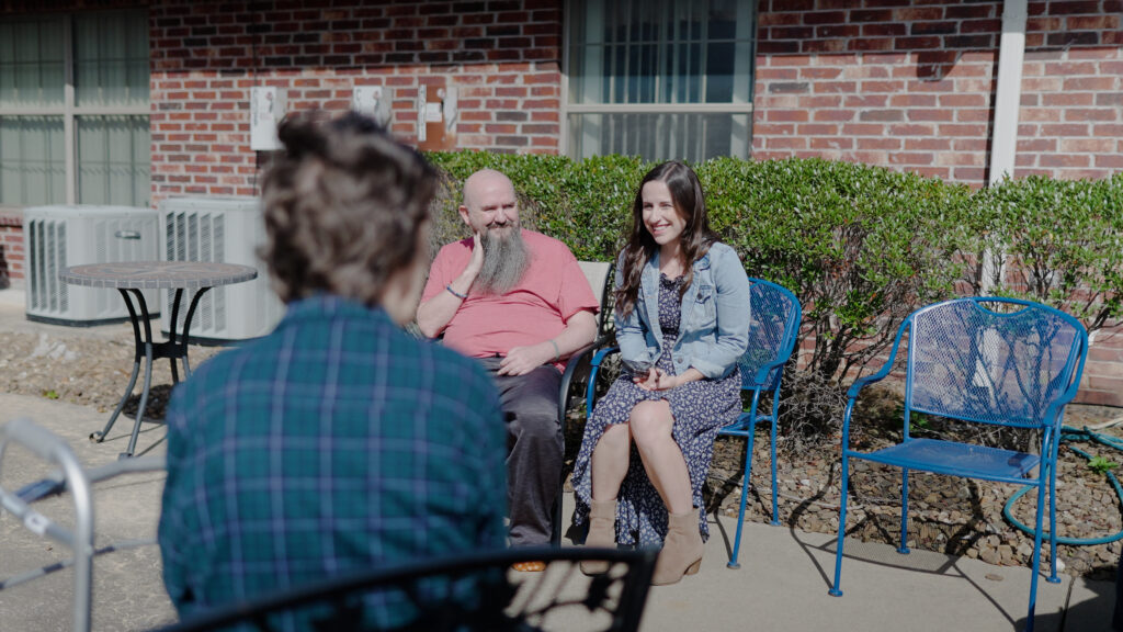 A group of people smiling and talking at a skilled nursing facility