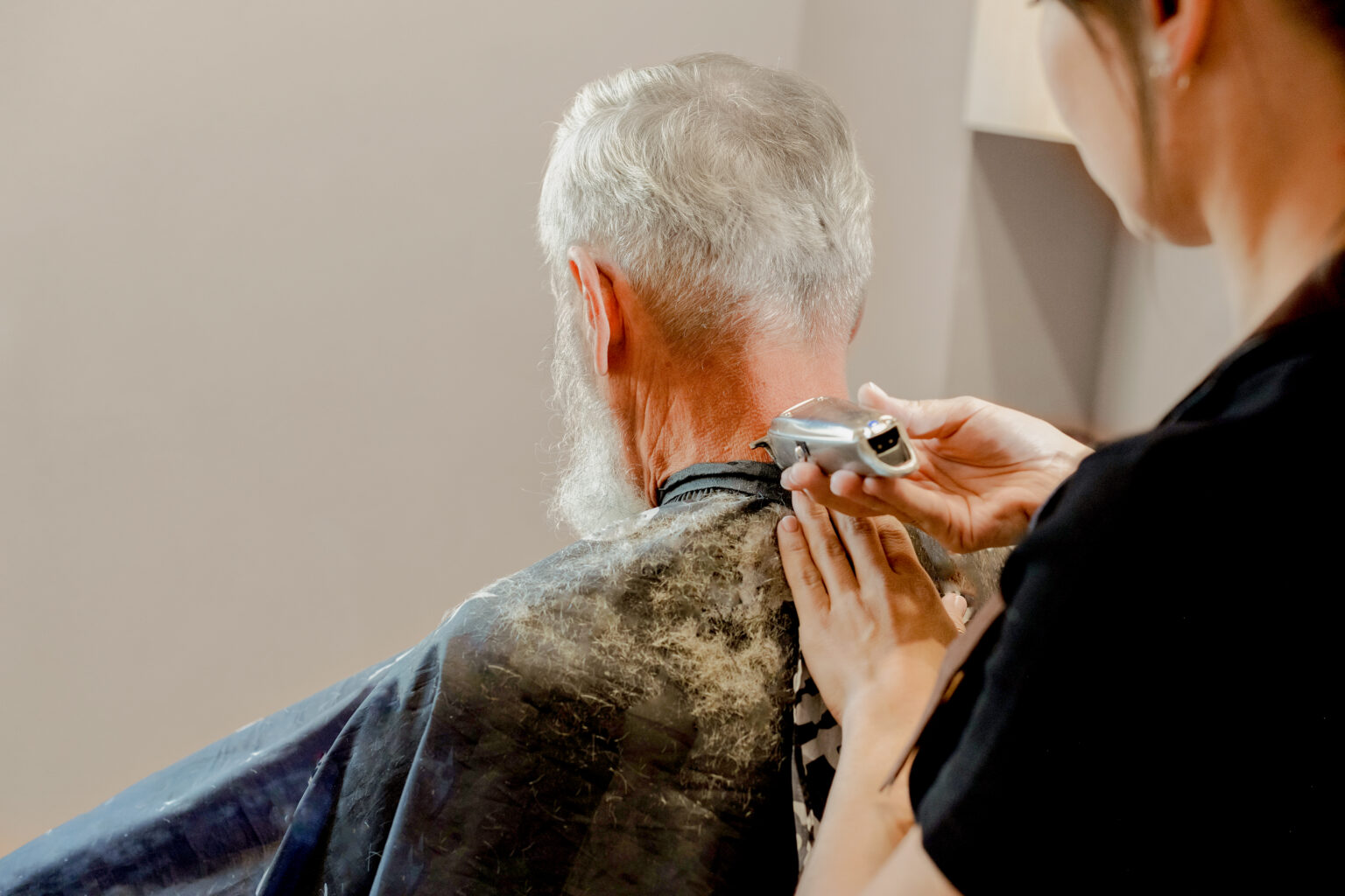 A man gets a haircut at a salon at a skilled nursing facility