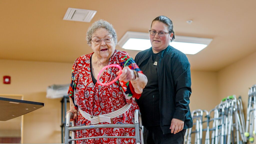 A woman is going through physical therapy with a nurse at a short term care facility